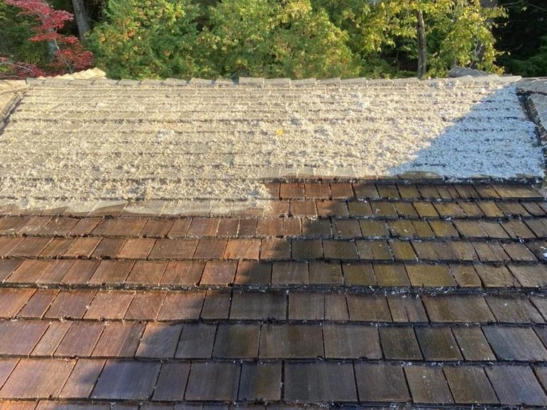 Cedar roof half way cleaned, showing the difference between clean and mossy cedar shake shingles