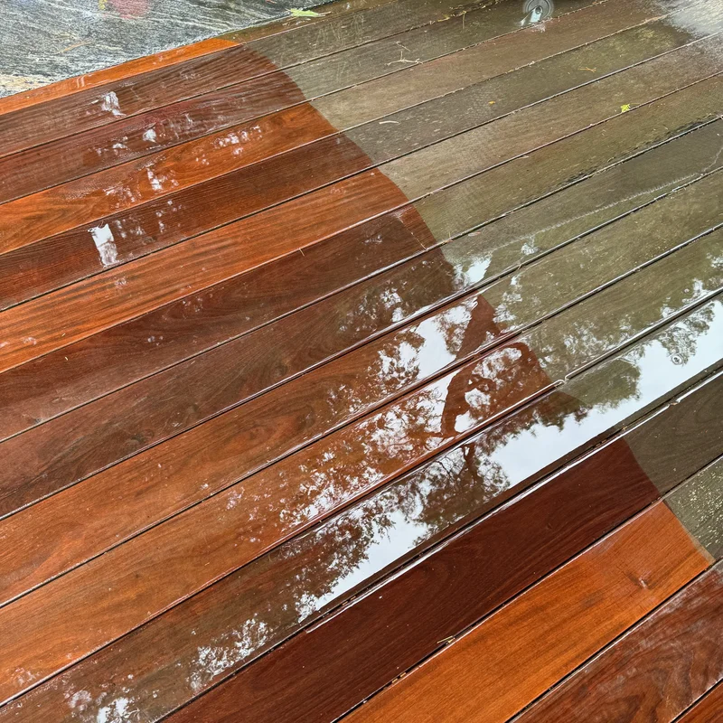 Deck cleaning in Muskoka in progress showing dramatic before and after comparison with grey weathered wood transformed to vibrant reddish-brown